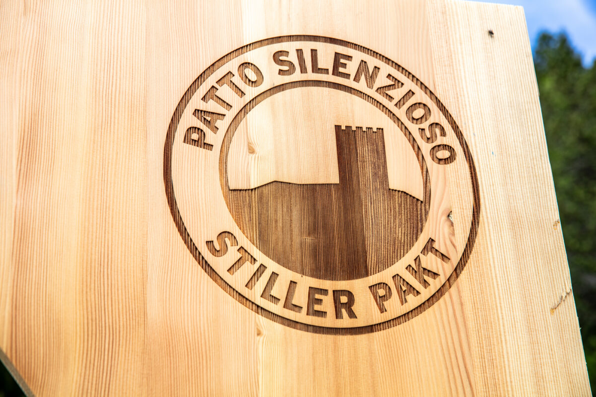 Eingebranntes Signet «Patto silenzioso – Stiller Pakt» auf einer Holztafel des Naturfensters Torre Belvedere