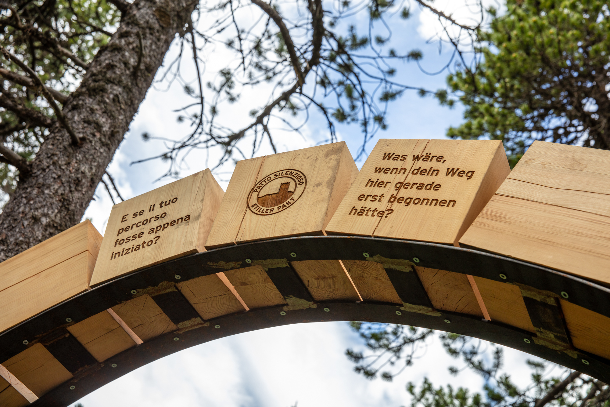Holzbogen aus Lärchenholz mit gravierten Texten an der Station «Hoffnung» des Themenwegs «Ein stiller Pakt»