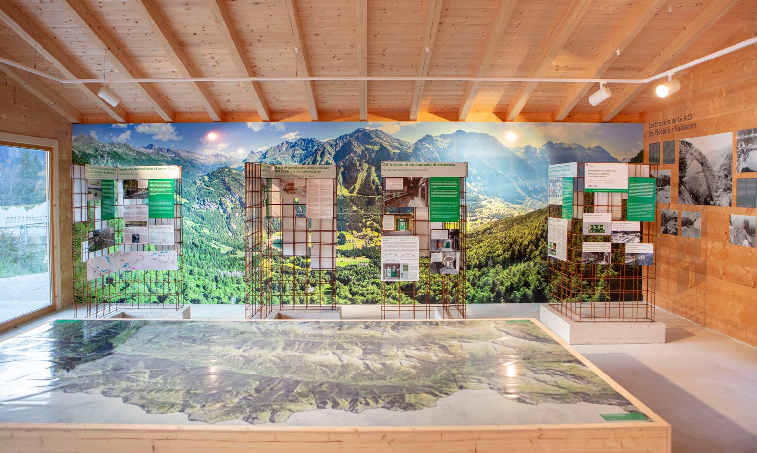 Ausstellungsraum des ASTRA Infopoint A13 mit grossem Relief der Strecke, Landschaftsbild und Themenelementen