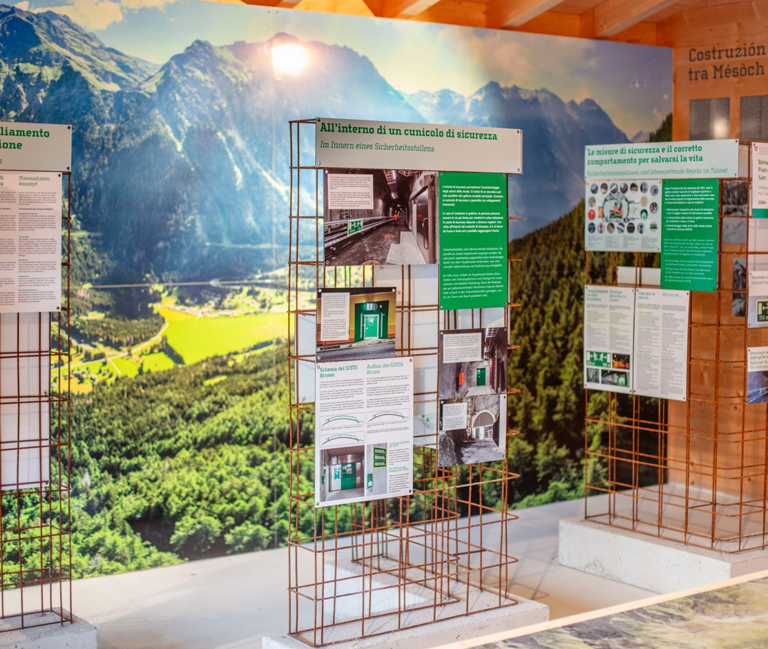 Themenelemente aus Armierungseisen vor grossformatigem Landschaftsbild des Misox im ASTRA Infopoint A13