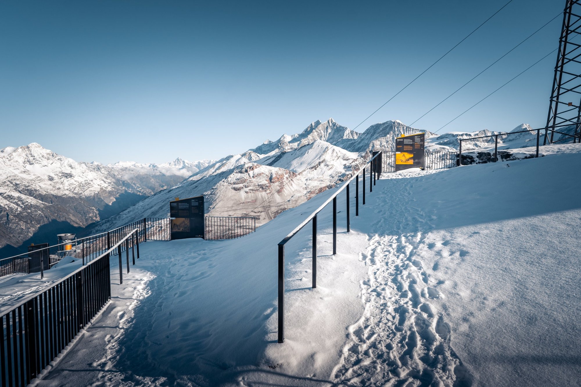Themenweg der Gornergrat Bahn: anthrazitfarbene Tafeln mit goldener Kante auf der verschneiten Gipfelplattform über 3000 m ü. M.