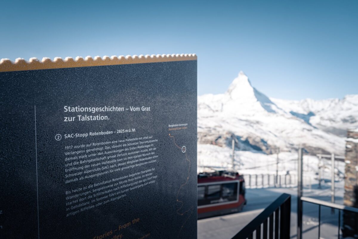 Tafel «Stationsgeschichten – Vom Grat zur Talstation» mit SAC-Stopp Rotenboden, im Hintergrund Matterhorn und Gornergrat Bahn